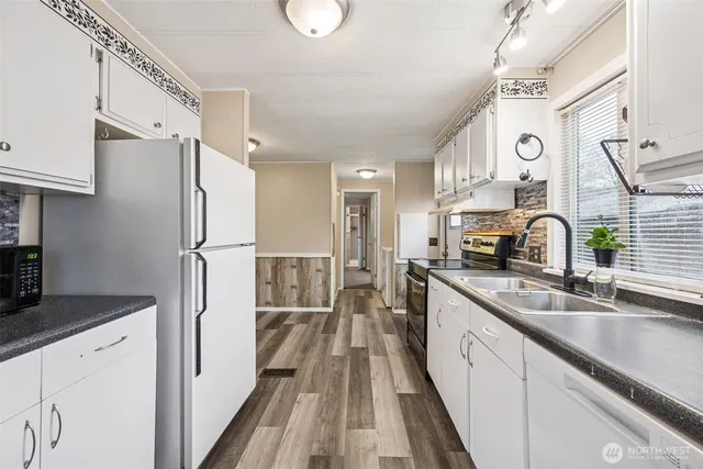 a kitchen with granite countertop a sink stove and refrigerator
