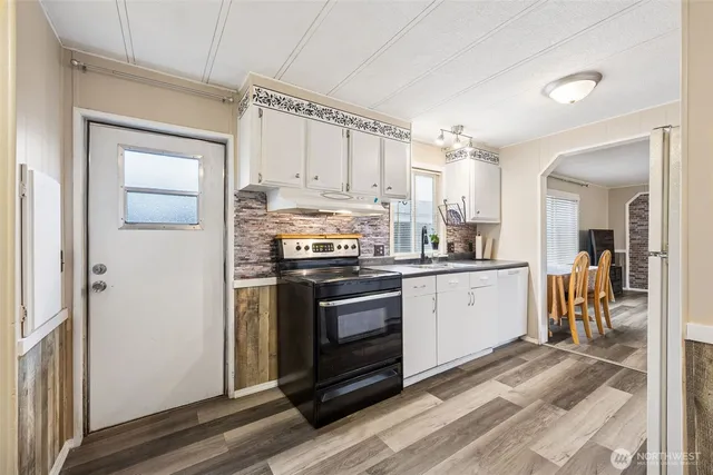 a kitchen with a refrigerator stove and white cabinets