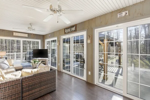 a living room with furniture a flat screen tv and windows