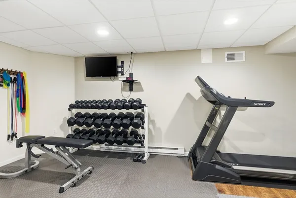 a room with gym equipment and a flat screen tv