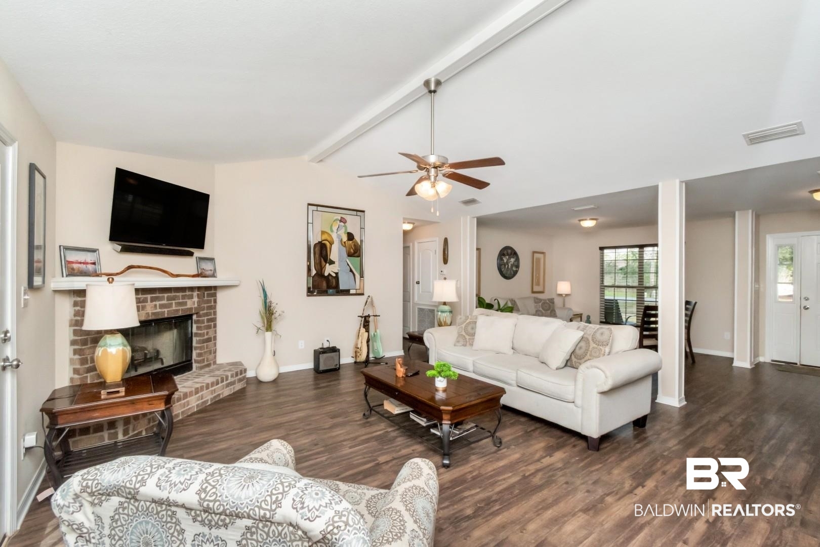 11528 Mocking Bird Lane Fairhope, AL 36532 - Photo 11 of 45 Living area featuring dark wood-style floors, a fireplace, vaulted ceiling with beams, and ceiling fan
