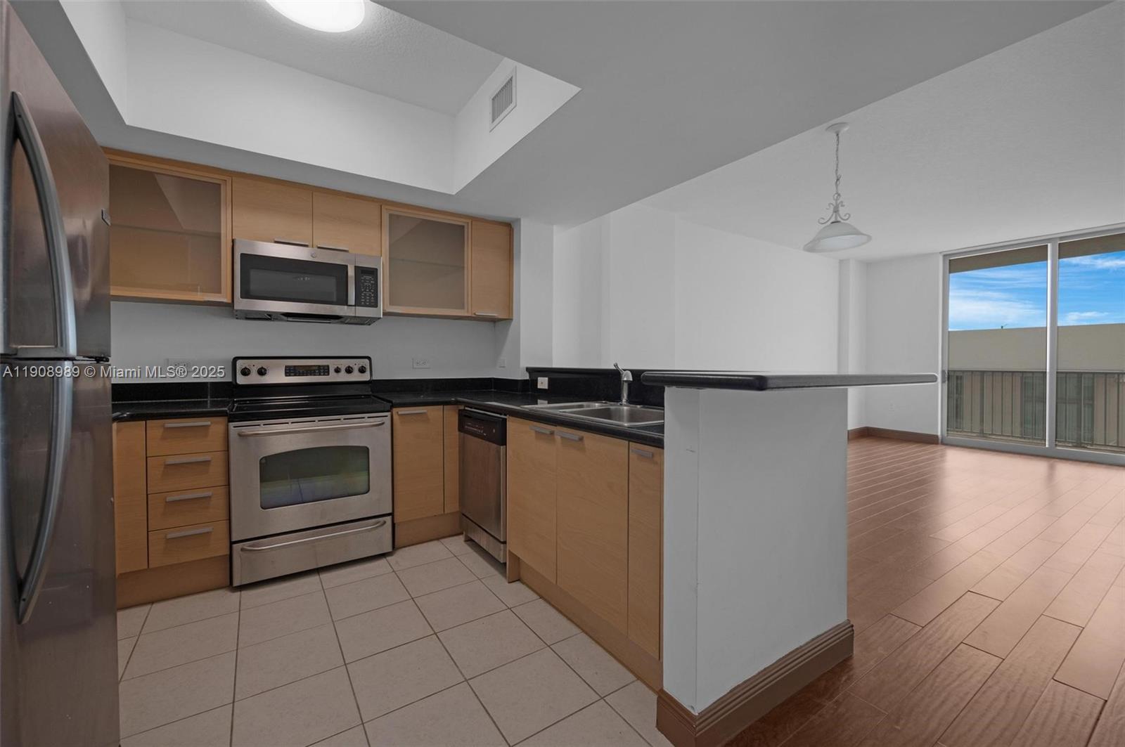 140 South Dixie Highway, Unit 533 Hollywood, FL 33020 - Photo 4 of 17 a kitchen with stainless steel appliances granite countertop a refrigerator and a stove top oven