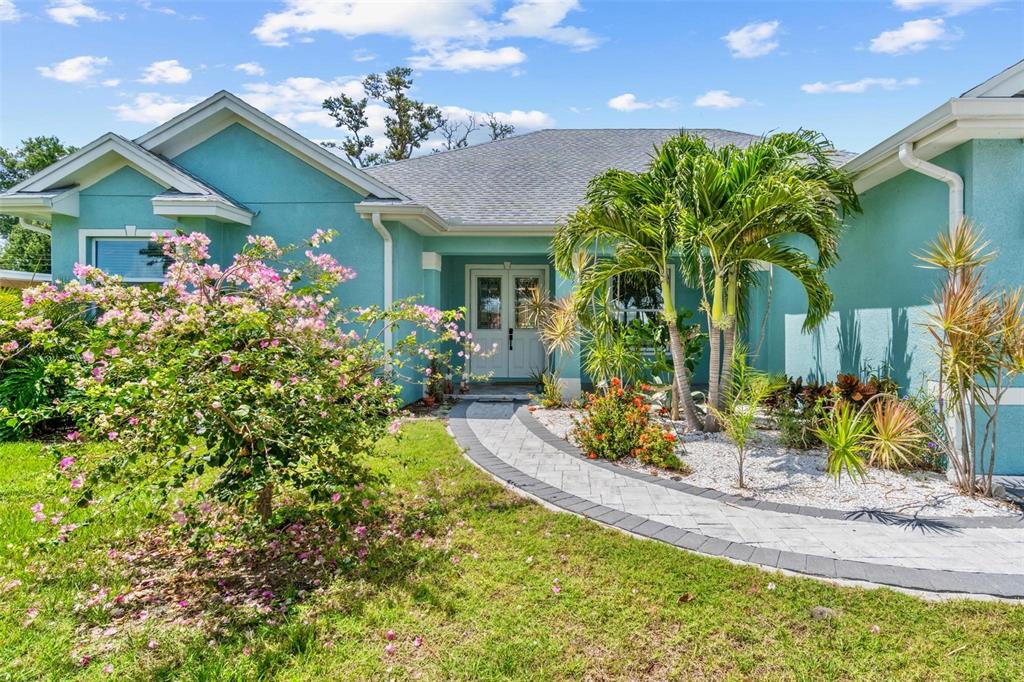 a front view of a house with a big yard and potted plants