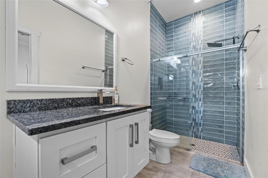 716 Laurel Avenue Venice, FL 34285 - Photo 21 of 42 a bathroom with a granite countertop toilet a sink a mirror and shower