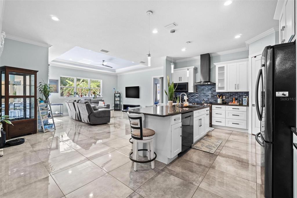 716 Laurel Avenue Venice, FL 34285 - Photo 8 of 42 a kitchen with stainless steel appliances kitchen island granite countertop a refrigerator oven a sink dishwasher and white cabinets with wooden floor