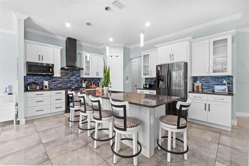 716 Laurel Avenue Venice, FL 34285 - Photo 10 of 42 a kitchen with stainless steel appliances kitchen island granite countertop a refrigerator and microwave
