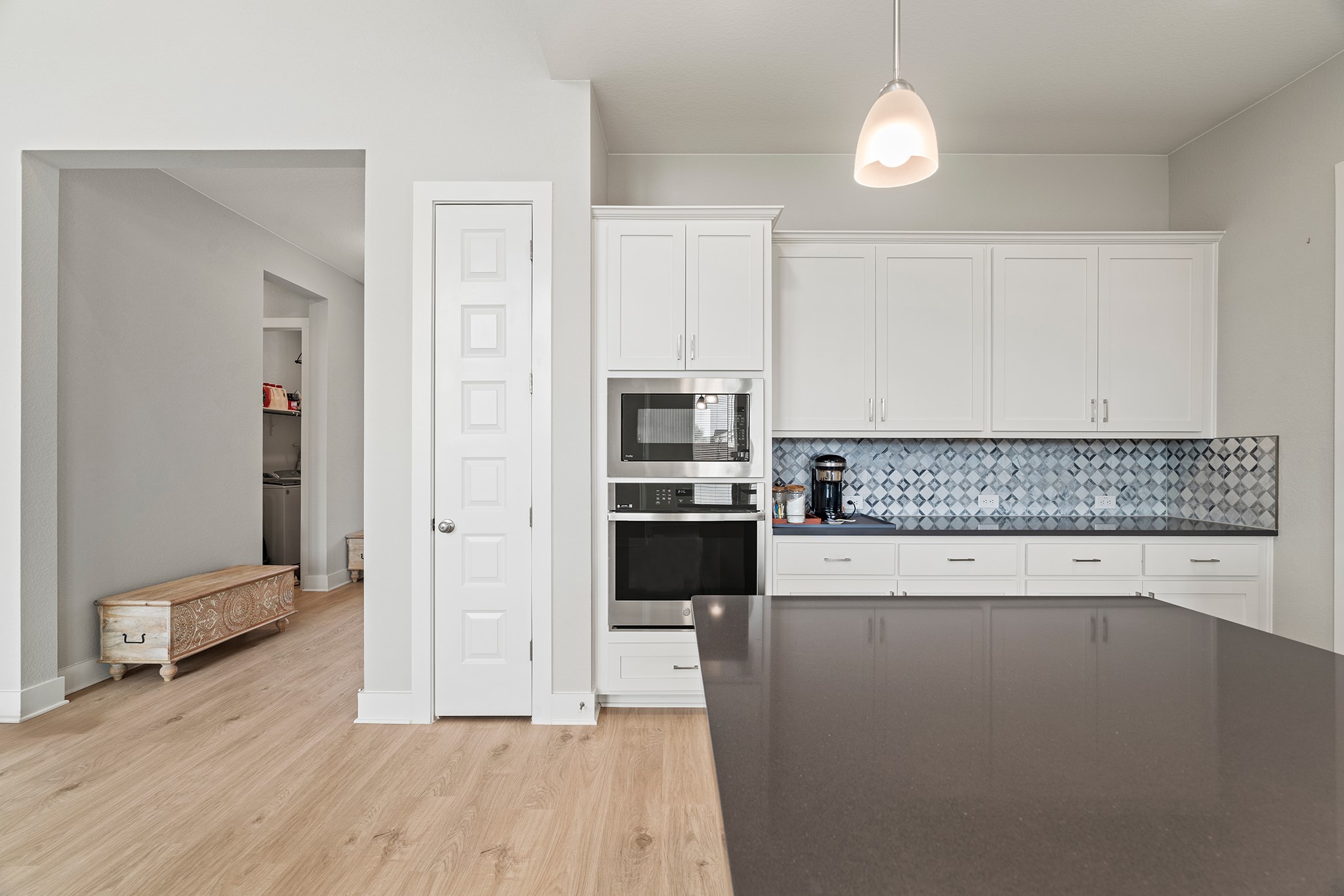 2112 Tobiano Trace Georgetown, TX 78633 - Photo 10 of 40 Kitchen featuring white cabinetry, stainless steel oven, light wood-style flooring, tasteful backsplash, and built in microwave
