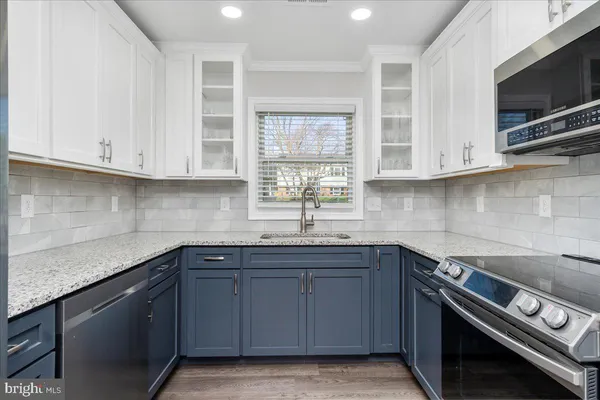 a kitchen with stainless steel appliances granite countertop a sink and a stove