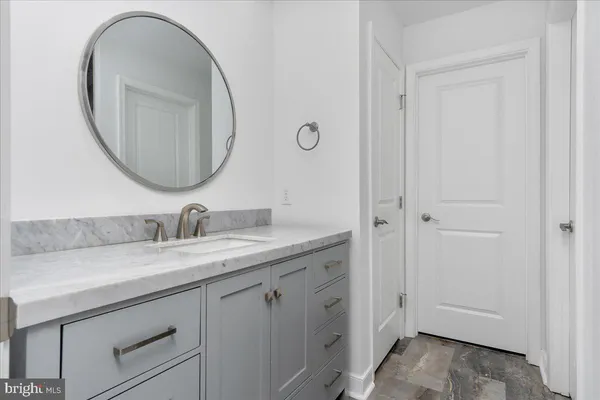 a bathroom with a granite countertop double vanity sink and a mirror
