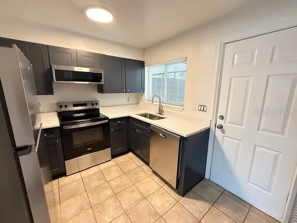 a kitchen with a sink stove and refrigerator