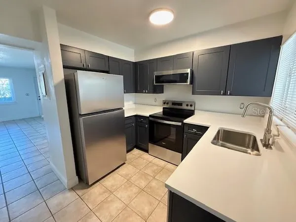 a kitchen with stainless steel appliances a refrigerator sink and microwave