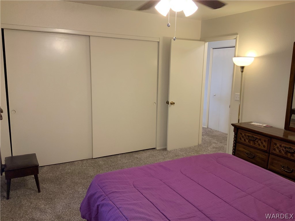 2052 Mesquite Lane, Unit 101 Laughlin, NV 89029 - Photo 21 of 32 a bedroom with a bed and a chandelier