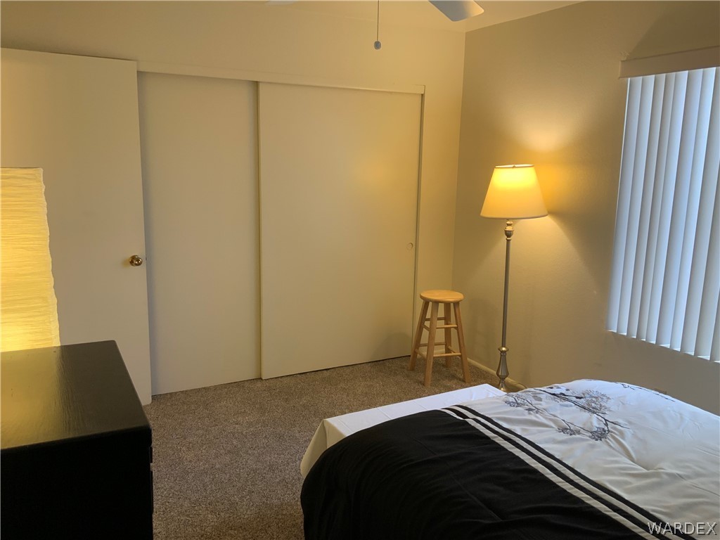 2052 Mesquite Lane, Unit 101 Laughlin, NV 89029 - Photo 27 of 32 a bedroom with a bed and a lamp on the dresser