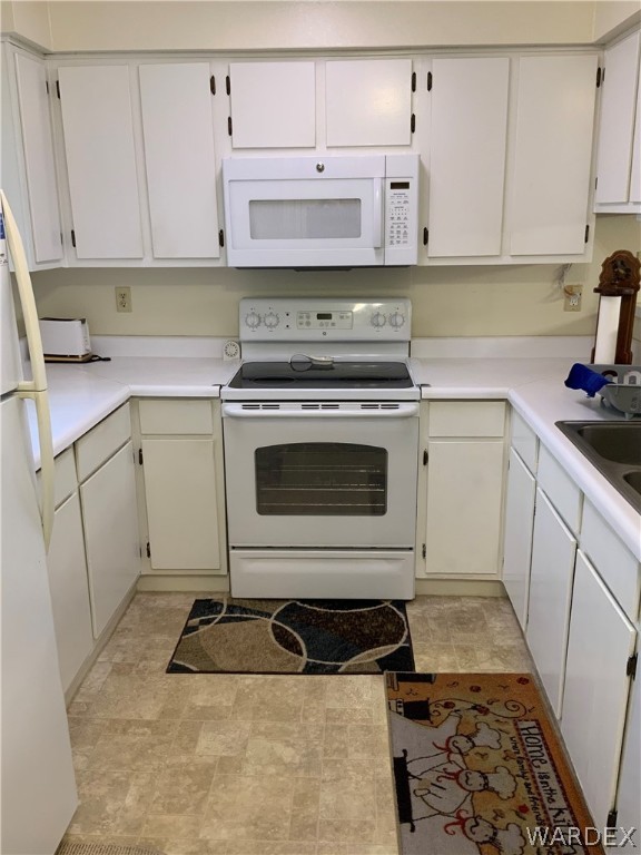 2052 Mesquite Lane, Unit 101 Laughlin, NV 89029 - Photo 7 of 32 a kitchen with granite countertop a sink a stove and cabinets