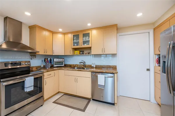 a kitchen with stainless steel appliances granite countertop a stove a refrigerator and a microwave