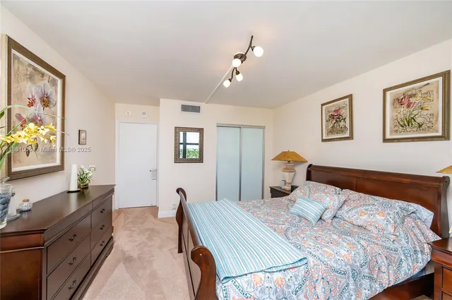 a bedroom with a bed and a dresser next to a window