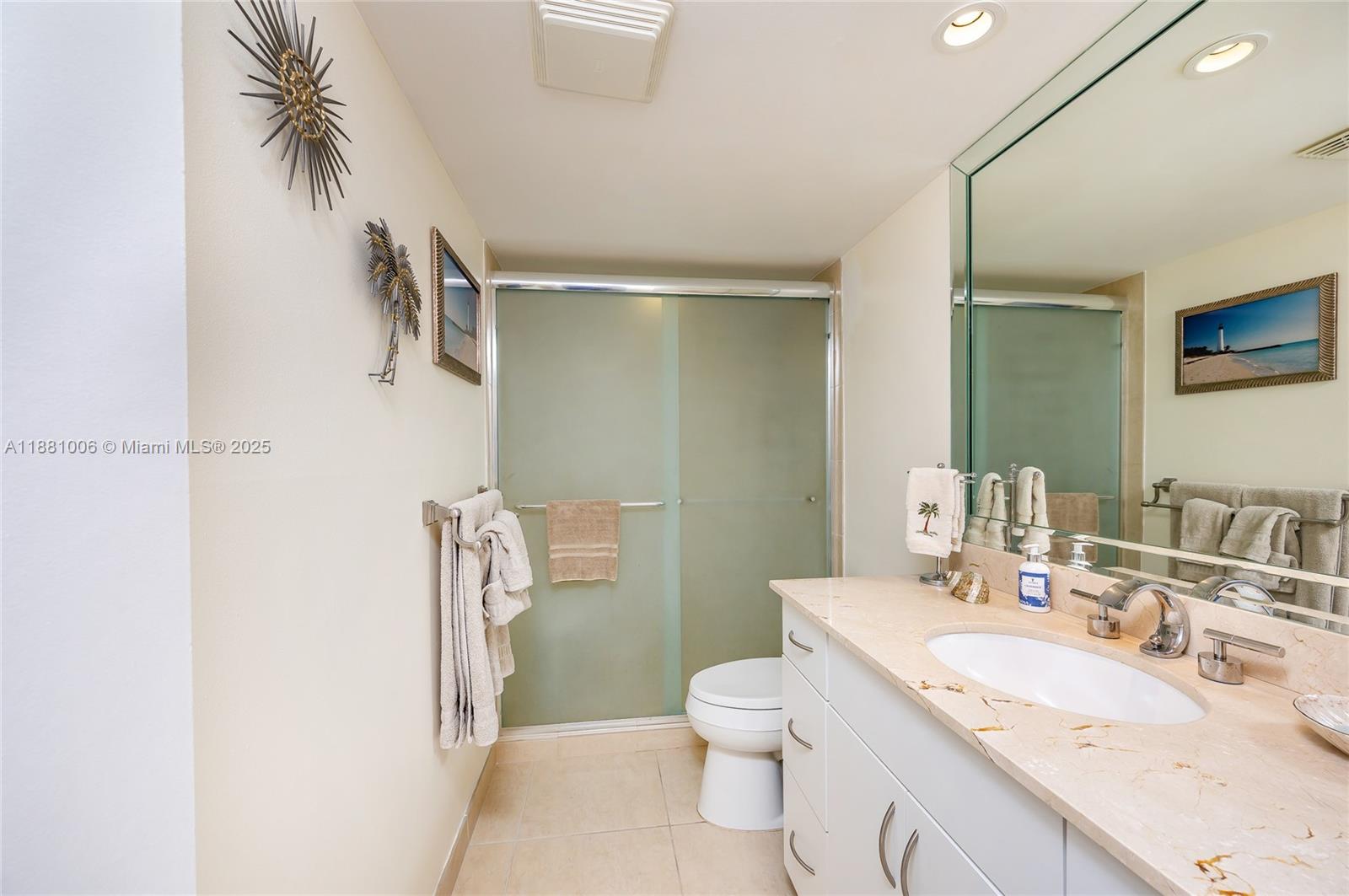 1121 Crandon Boulevard, Unit E501 Key Biscayne, FL 33149 - Photo 23 of 44 a bathroom with a granite countertop sink a toilet and a shower