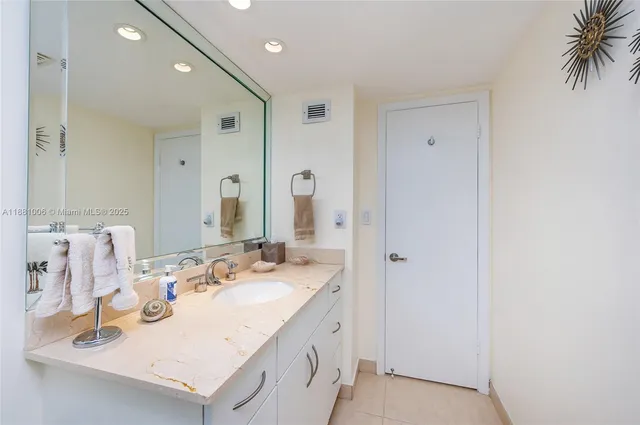 a spacious bathroom with a double vanity sink a mirror and a shower