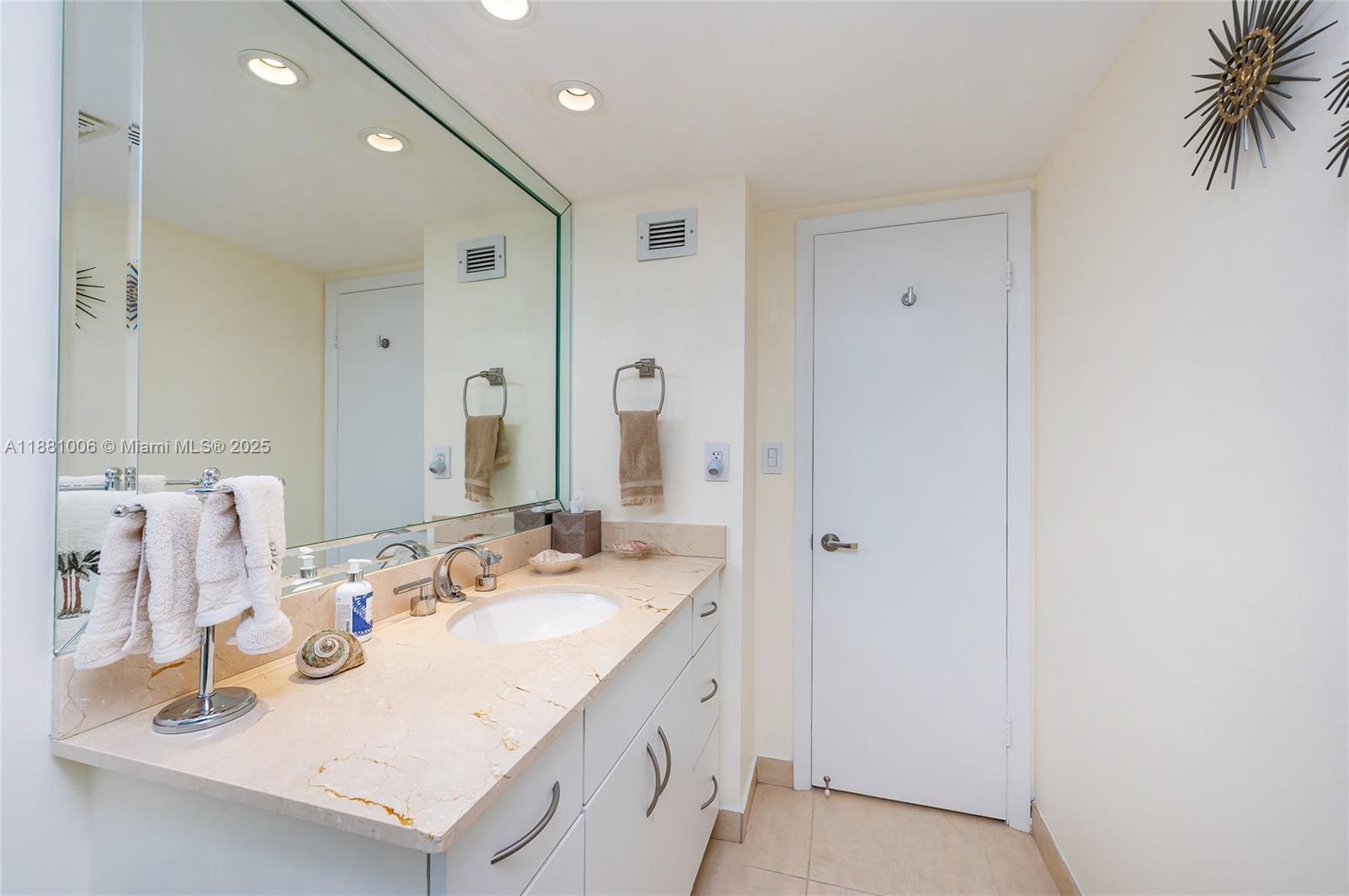 1121 Crandon Boulevard, Unit E501 Key Biscayne, FL 33149 - Photo 25 of 44 a bathroom with a sink vanity and a mirror