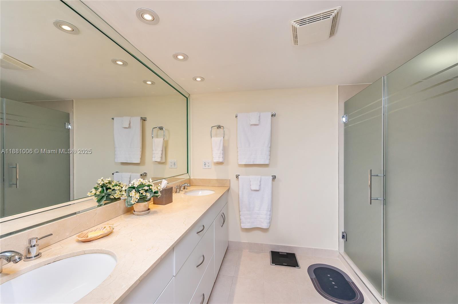1121 Crandon Boulevard, Unit E501 Key Biscayne, FL 33149 - Photo 26 of 44 a spacious bathroom with a double vanity sink a mirror and a shower