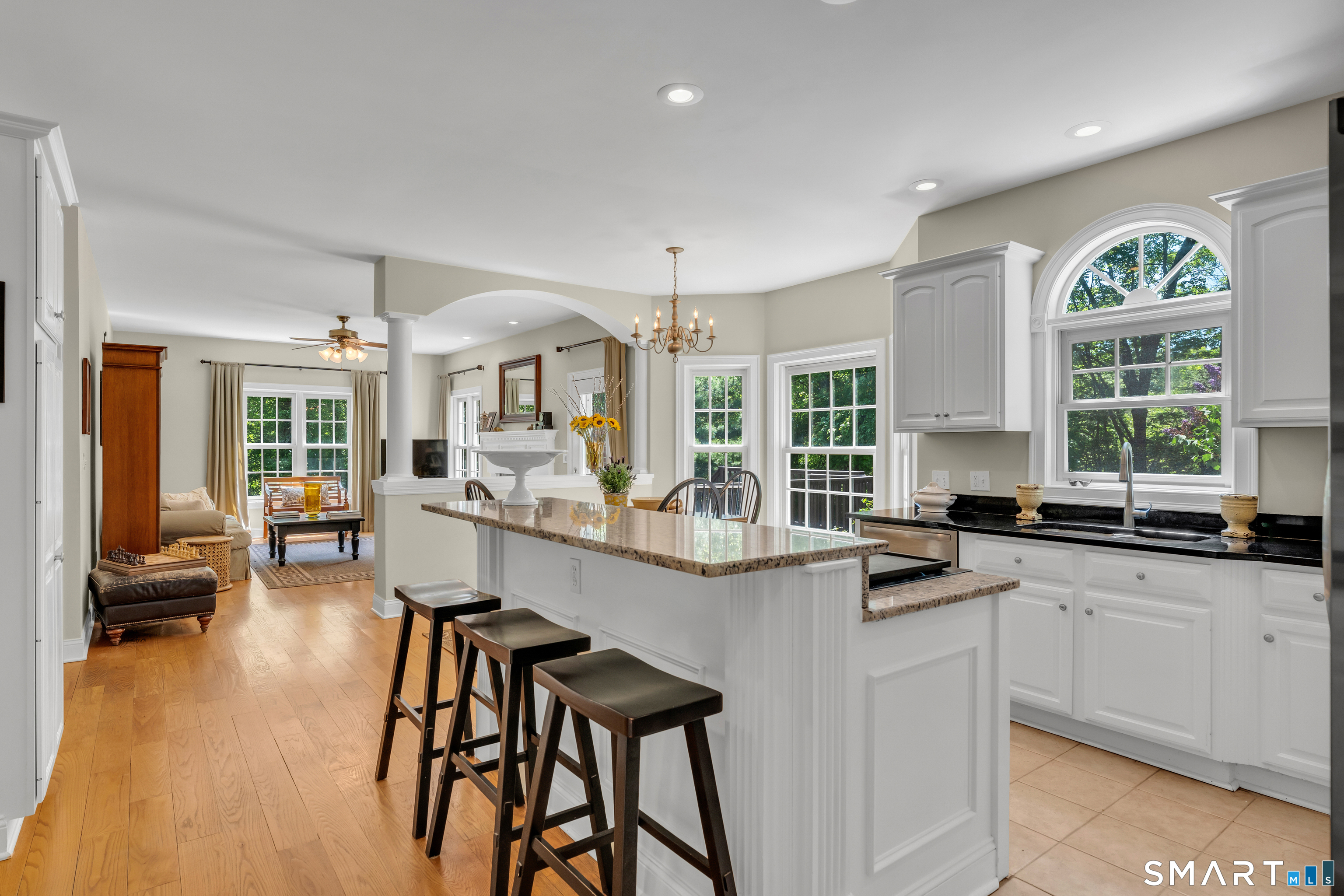 474 State Street Guilford, CT 06437 - Photo 13 of 40 a kitchen with stainless steel appliances granite countertop a stove a sink dishwasher a dining table and chairs with wooden floor