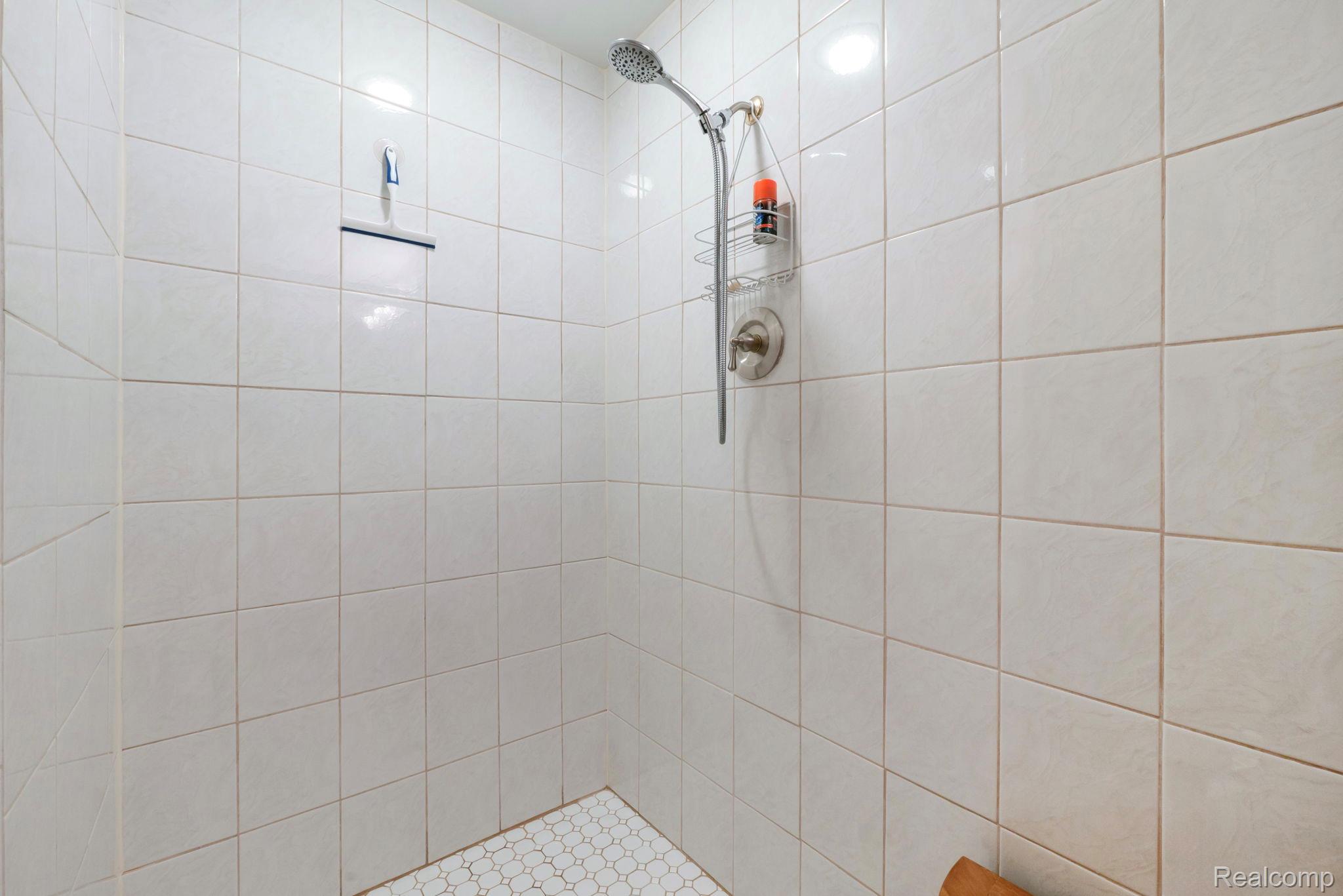 1902 Grayslake Drive Rochester, MI 48306 - Photo 55 of 76 Shower enclosure featuring white square wall tiles and white hexagonal floor tiles