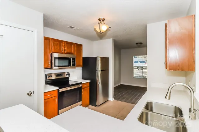 a kitchen with stainless steel appliances granite countertop a refrigerator a stove top oven a sink and dishwasher