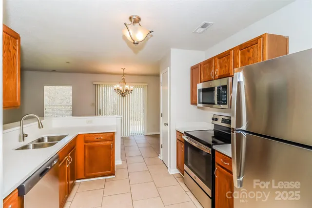 a kitchen with stainless steel appliances granite countertop a sink and a stove top oven
