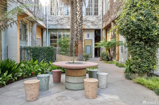 a view of a house with potted plants and a fountain