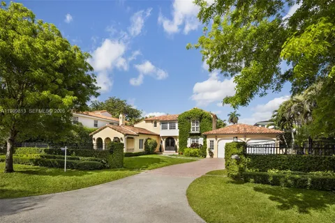a view of a big yard with plants and large trees