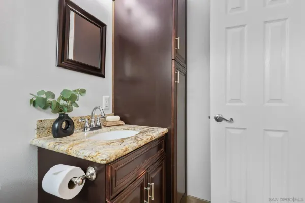 a bathroom with a granite countertop sink and a mirror
