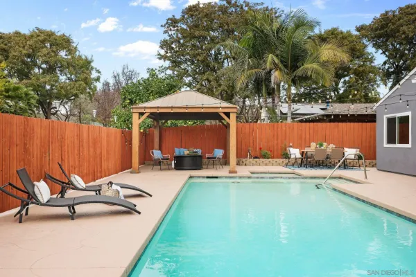 a view of a house with pool and a yard
