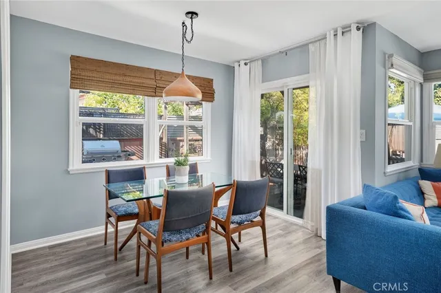 a dining room with furniture a chandelier and wooden floor
