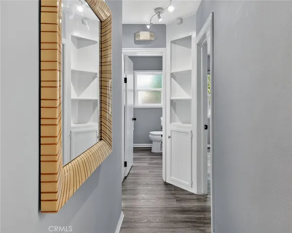 a view of a hallway with wooden floor and staircase