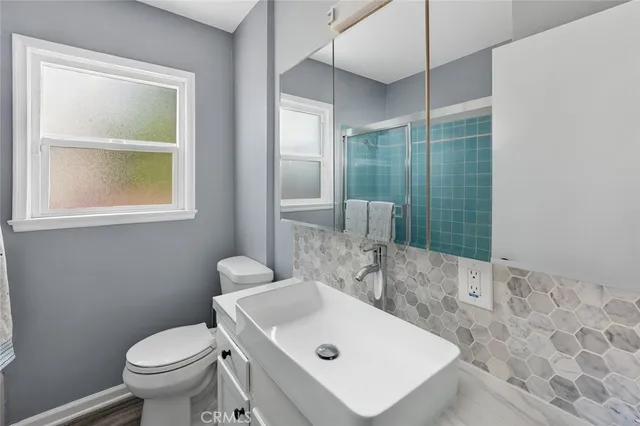 a bathroom with a sink a toilet and shower