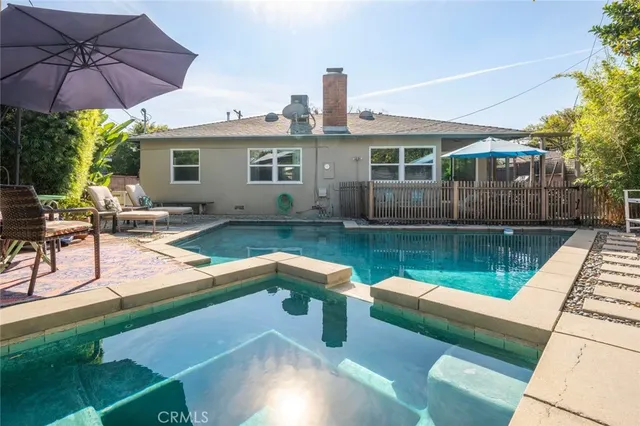 a view of a patio with couches chairs under an umbrella