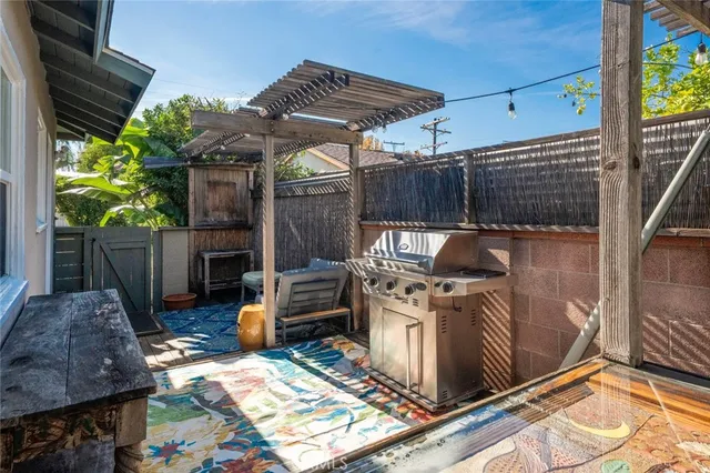 a view of a backyard with table and chairs a barbeque with wooden fence