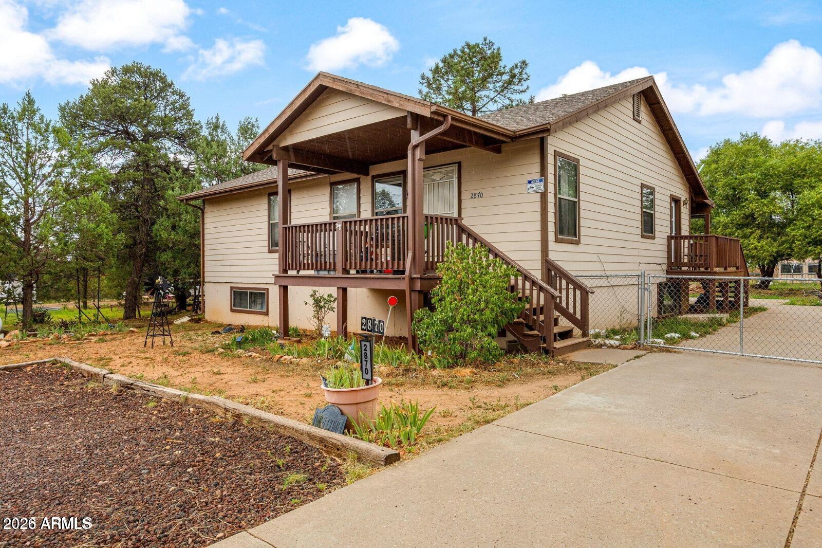 2870 Mustang Trail Overgaard, AZ 85933 - Photo 1 of 17 a front view of a house with garden
