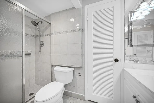 a white toilet sitting next to a shower