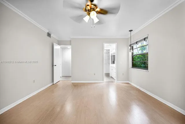 an empty room with a chandelier fan and closet area