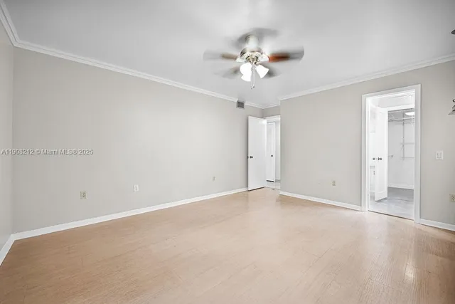 a view of a hallway with wooden floor and a bathroom