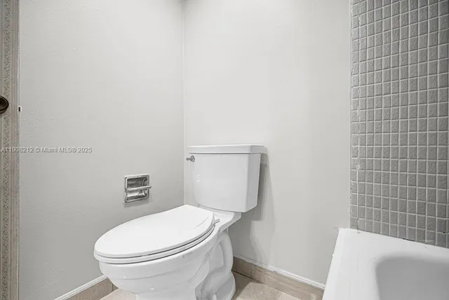 a view of a hallway to kitchen with cabinets and wooden floor