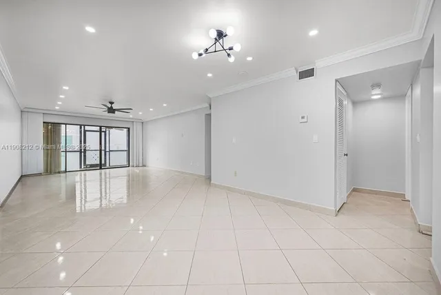 an empty room with kitchen and chandelier