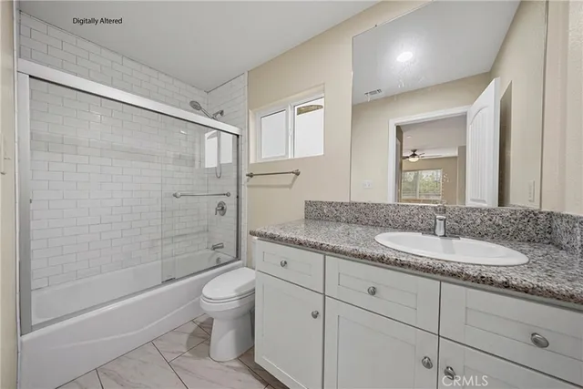 a bathroom with a granite countertop sink a toilet and shower