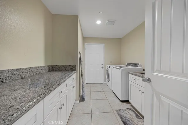 a utility room with cabinets washer and dryer