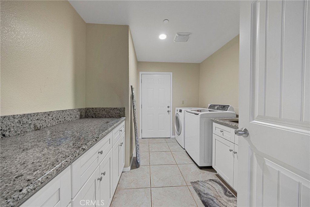 65 Tennessee Street Redlands, CA 92373 - Photo 19 of 23 a utility room with cabinets washer and dryer