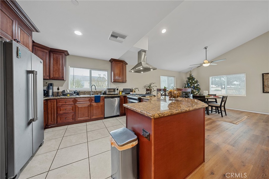 65 Tennessee Street Redlands, CA 92373 - Photo 5 of 23 a kitchen with stainless steel appliances kitchen island granite countertop a sink refrigerator and cabinets