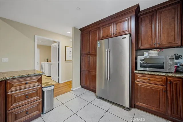 a kitchen with stainless steel appliances granite countertop a refrigerator and a stove top oven