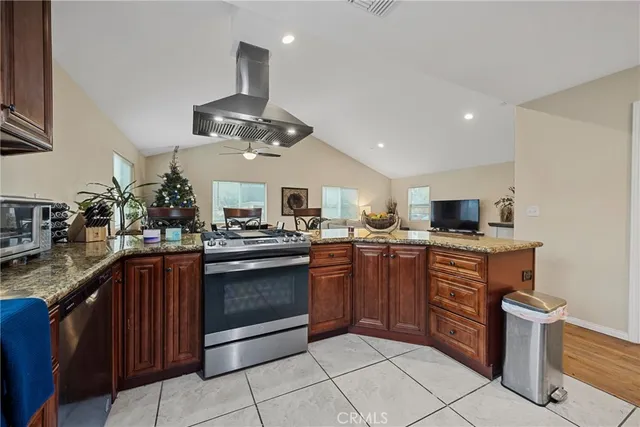 a kitchen with stainless steel appliances granite countertop a sink counter space cabinets and a stove