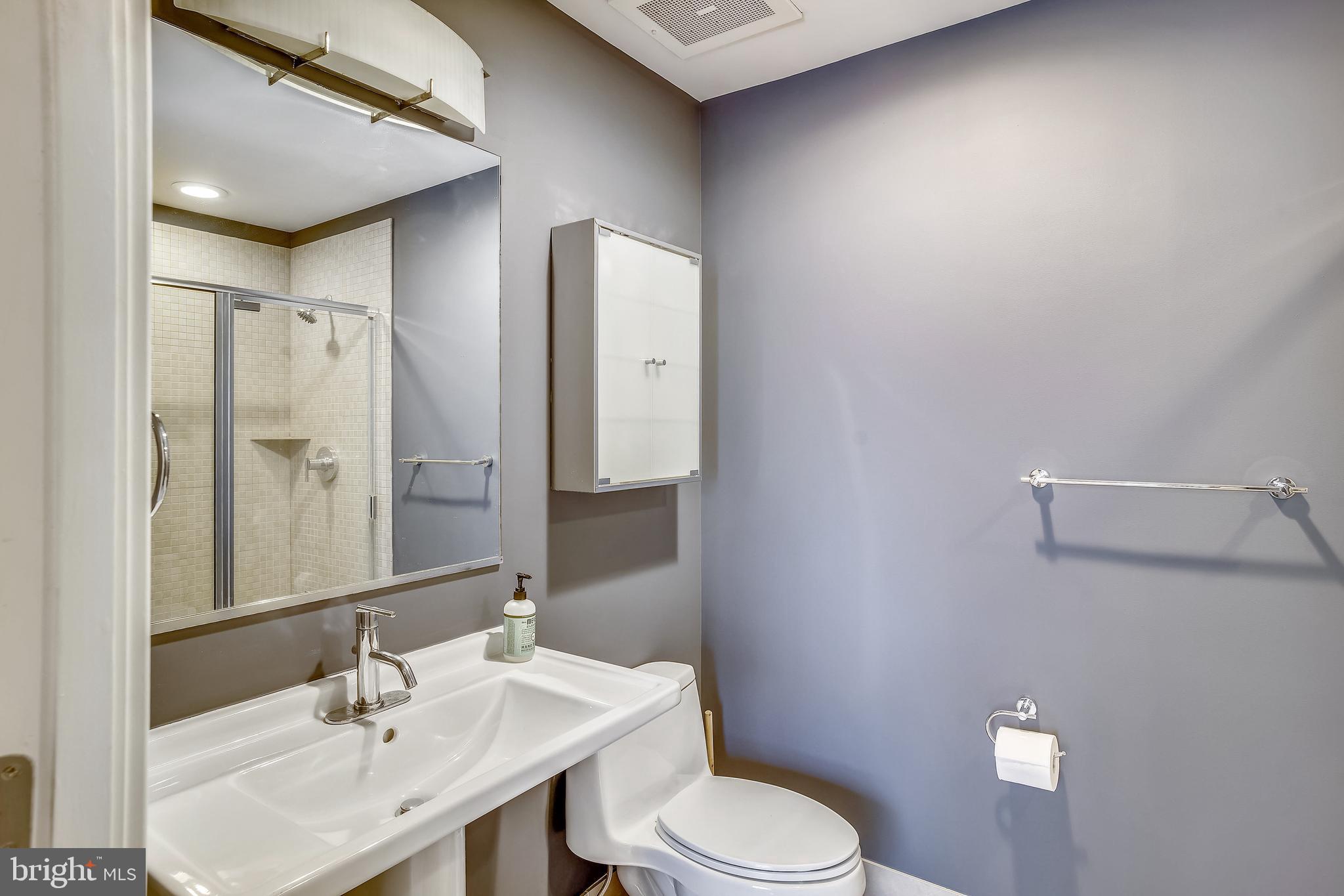 2125 14th Street Northwest, Unit 212 Washington, DC 20009 - Photo 14 of 21 a bathroom with a toilet a sink a mirror and vanity